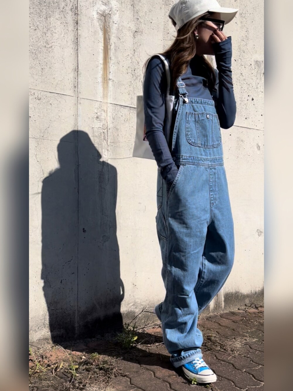 ブルー系のサロペット/オーバーオール、ブルー系のTシャツ/カットソー、ブルー系のスニーカーを着用したレディースの秋コーディネートの2枚目の写真