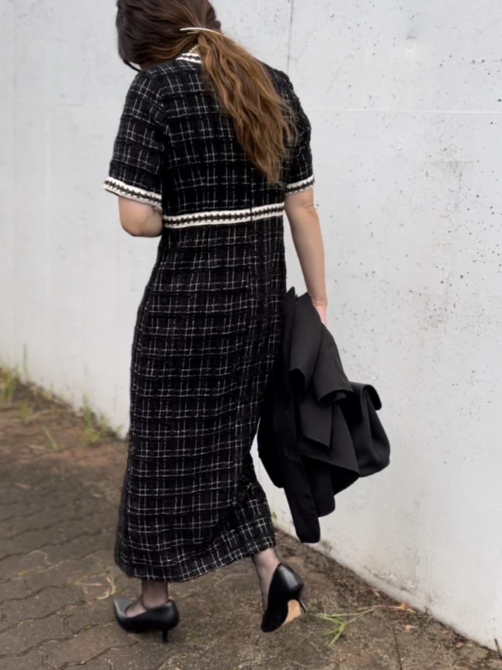 ホワイト系のドレス、ブラック系のパンプス、ブラック系のテーラードジャケットを着用したレディースの秋コーディネートの3枚目の写真