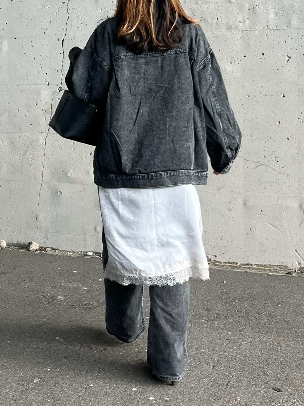ブラック系のデニムジャケット、グレー系のワンピース、ブラック系のパンプスを着用したレディースの冬コーディネートの5枚目の写真