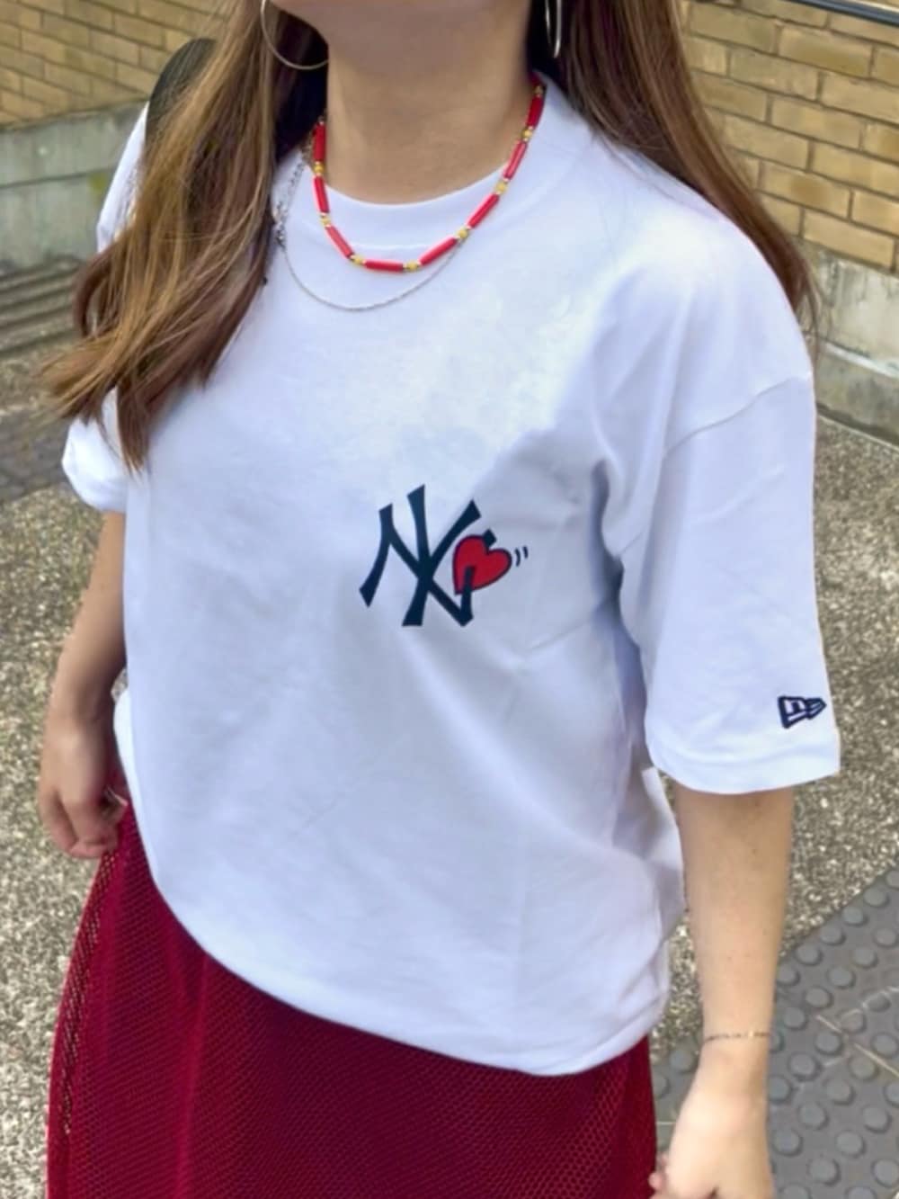 ホワイト系のTシャツ/カットソー、ブラック系のボディバッグ/ウエストポーチ、ブルー系のデニムパンツを着用したレディースの夏コーディネートの4枚目の写真