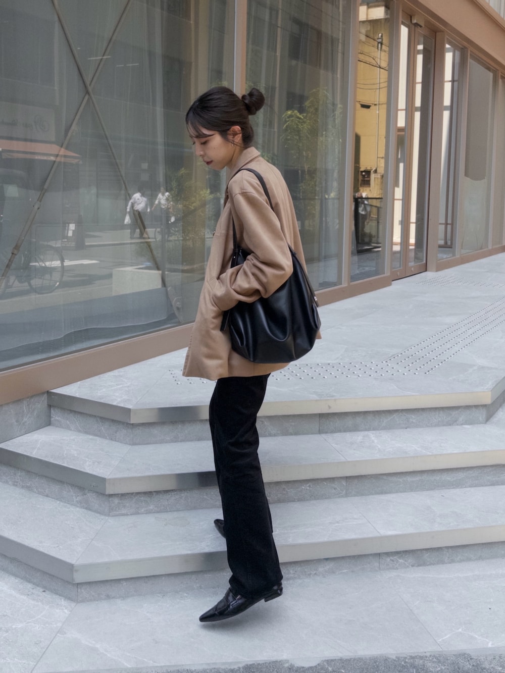 ベージュ系のブルゾン、ブルー系のデニムパンツ、ブラック系のローファーを着用したレディースの秋コーディネートの2枚目の写真