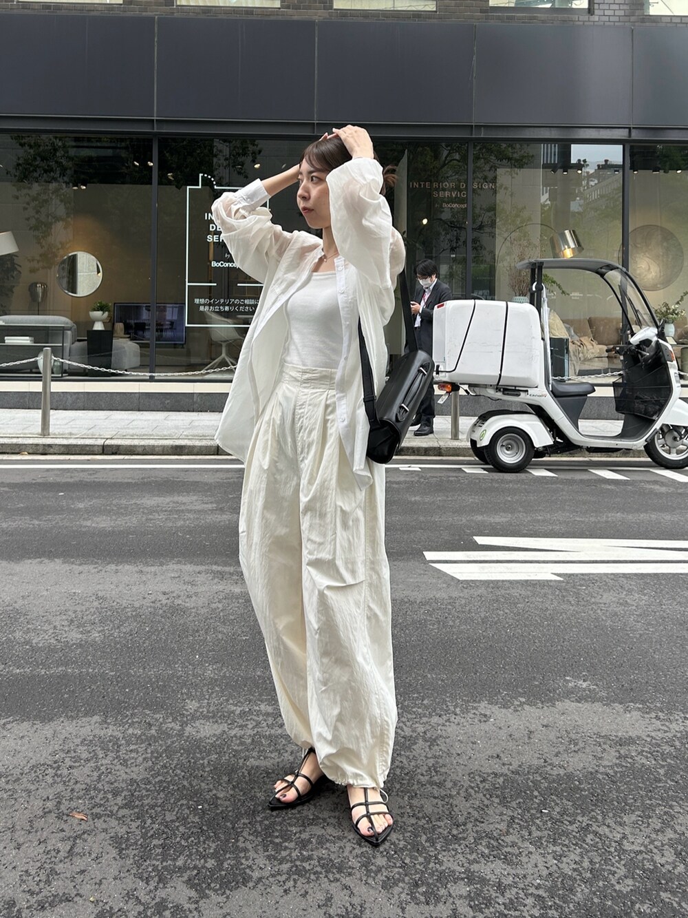 ホワイト系のシャツ/ブラウス、ブラック系のサンダル、ブラック系のショルダーバッグを着用したレディースの春コーディネートの2枚目の写真