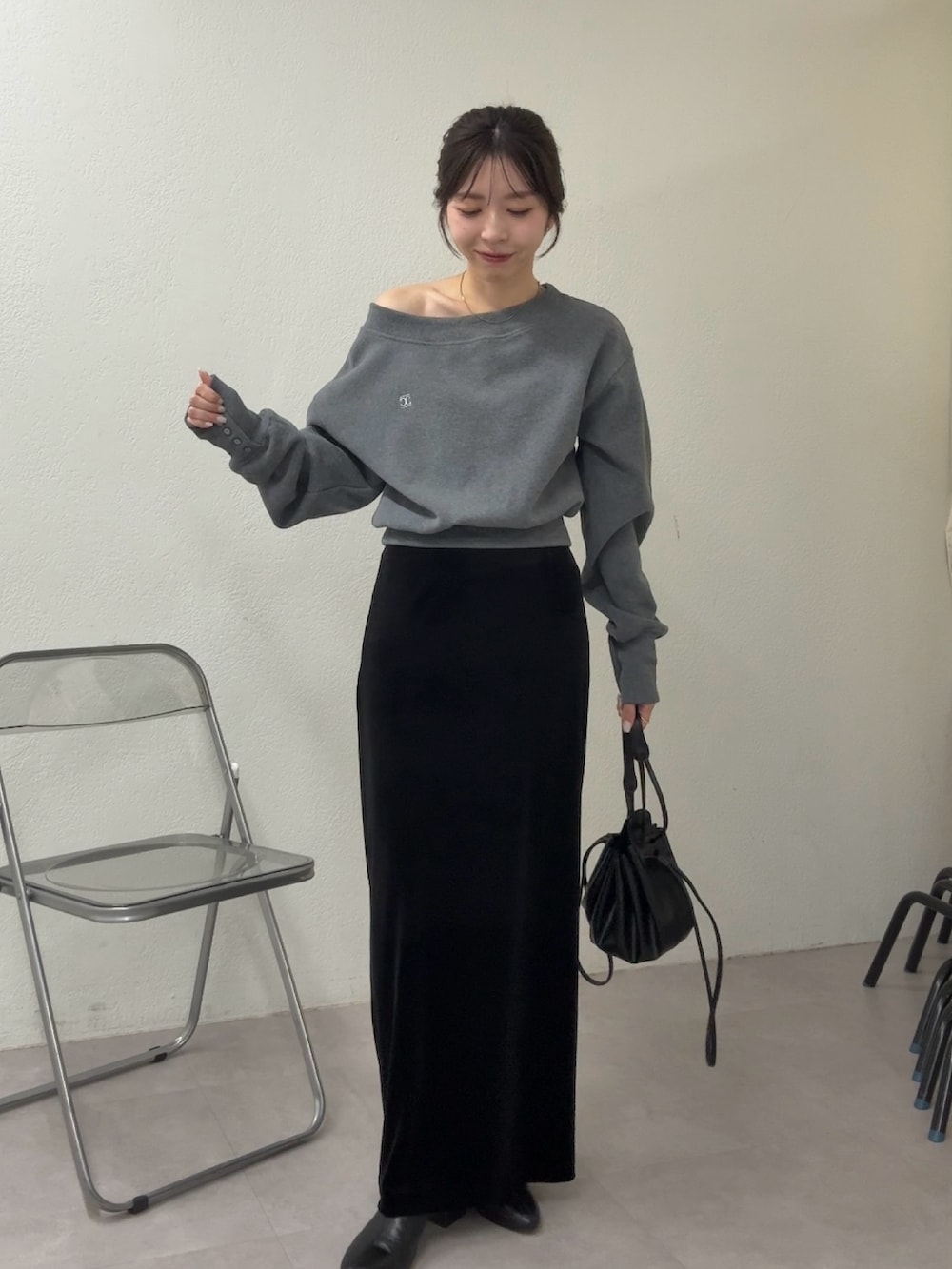 グレー系のTシャツ/カットソー、ブラック系のスカート、ブラック系のショルダーバッグを着用したレディースの冬コーディネートの2枚目の写真