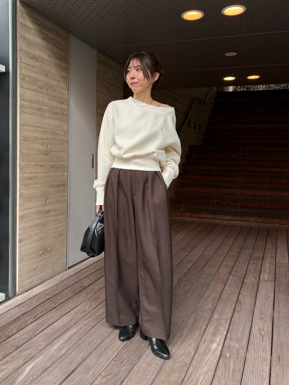 ホワイト系のTシャツ/カットソー、ブラック系のショルダーバッグ、ブラウン系のその他パンツを着用したレディースの秋コーディネートの2枚目の写真