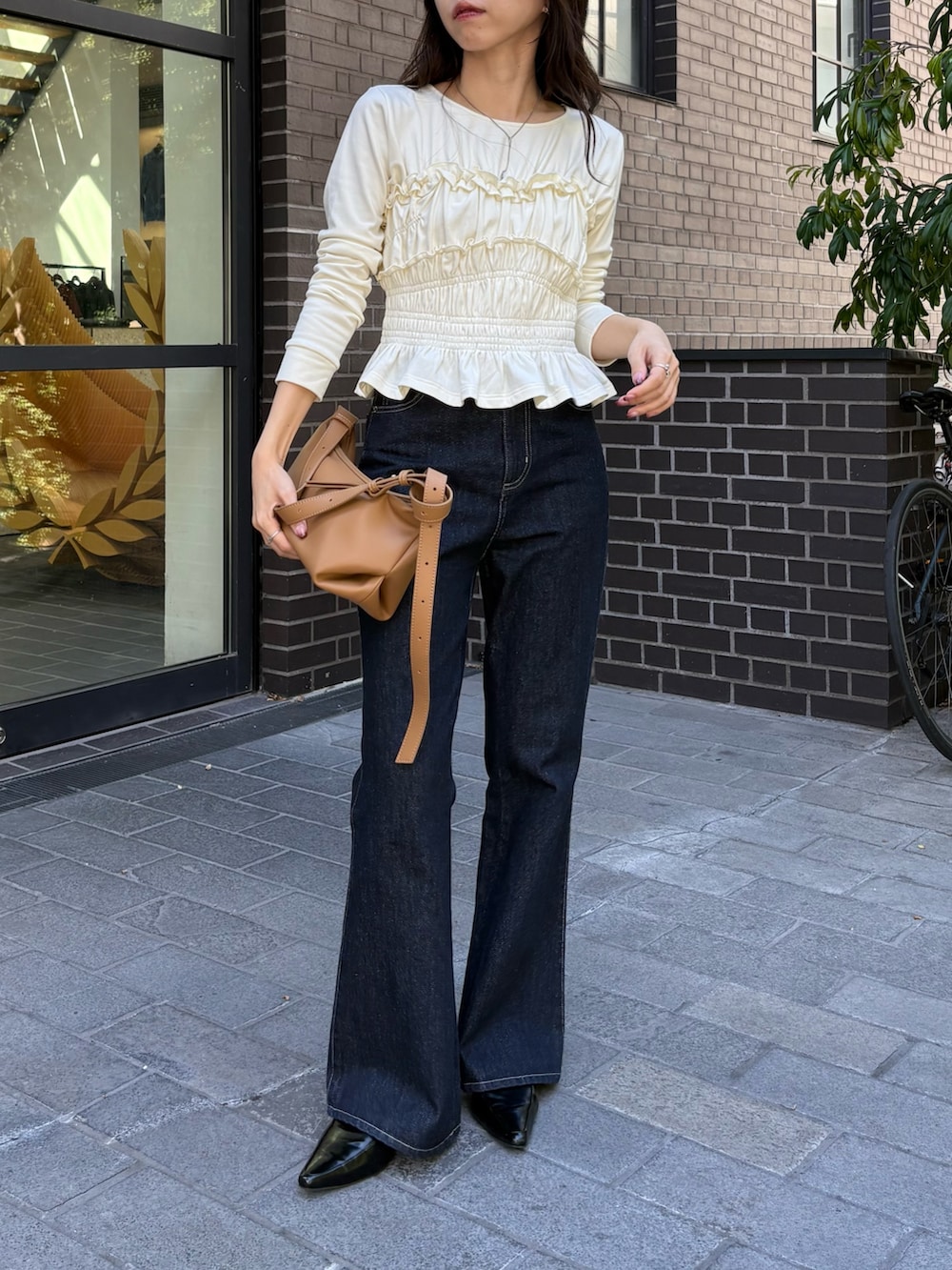 ホワイト系のTシャツ/カットソー、イエロー系のショルダーバッグ、ブルー系のデニムパンツを着用したレディースの秋コーディネートの2枚目の写真