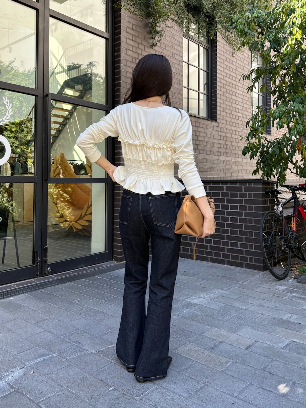 ホワイト系のTシャツ/カットソー、イエロー系のショルダーバッグ、ブルー系のデニムパンツを着用したレディースの秋コーディネートの3枚目の写真