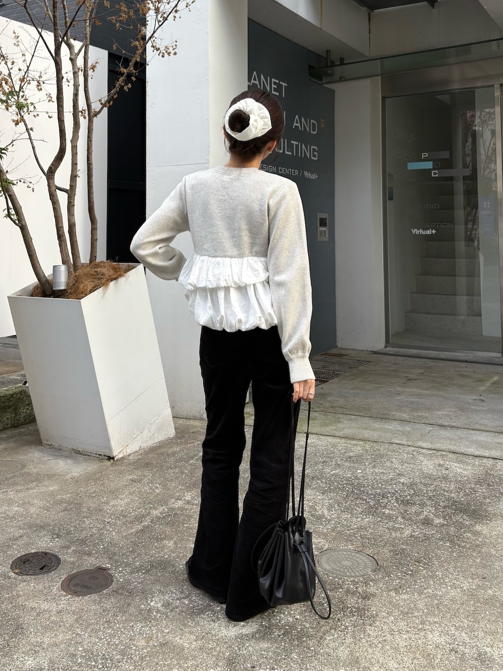 グレー系のニット/セーター、ブラック系のその他パンツ、ブラック系のショルダーバッグを着用したレディースの秋コーディネートの4枚目の写真