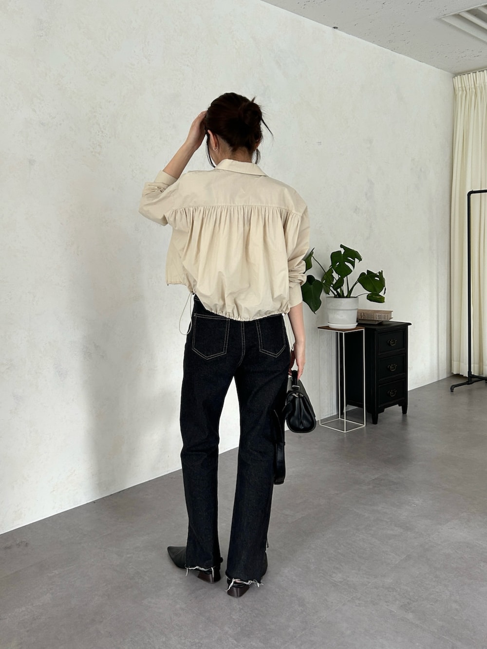 ベージュ系のシャツ/ブラウス、ブラック系のショルダーバッグ、ブラック系のデニムパンツを着用したレディースの春コーディネートの2枚目の写真