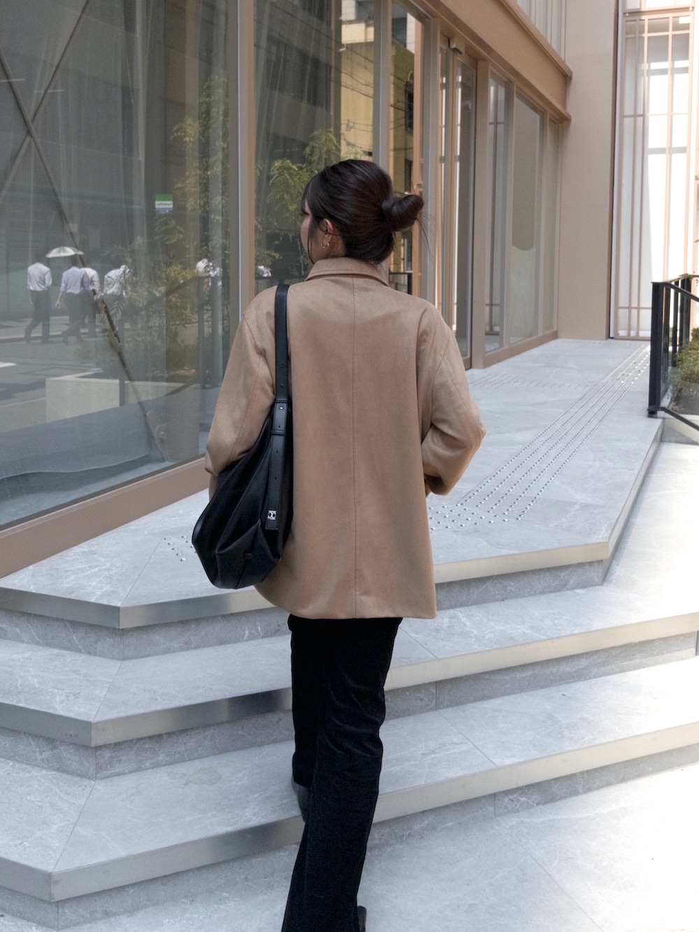 ベージュ系のブルゾン、ブルー系のデニムパンツ、ブラック系のローファーを着用したレディースの秋コーディネートの3枚目の写真