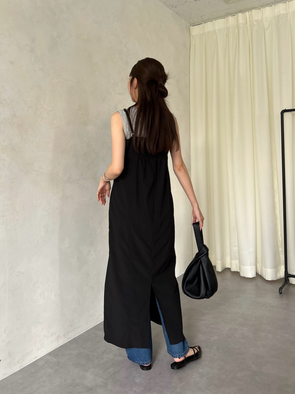 ブラック系のワンピース、ブラック系のタンクトップ、ブラック系のハンドバッグを着用したレディースの春コーディネートの2枚目の写真