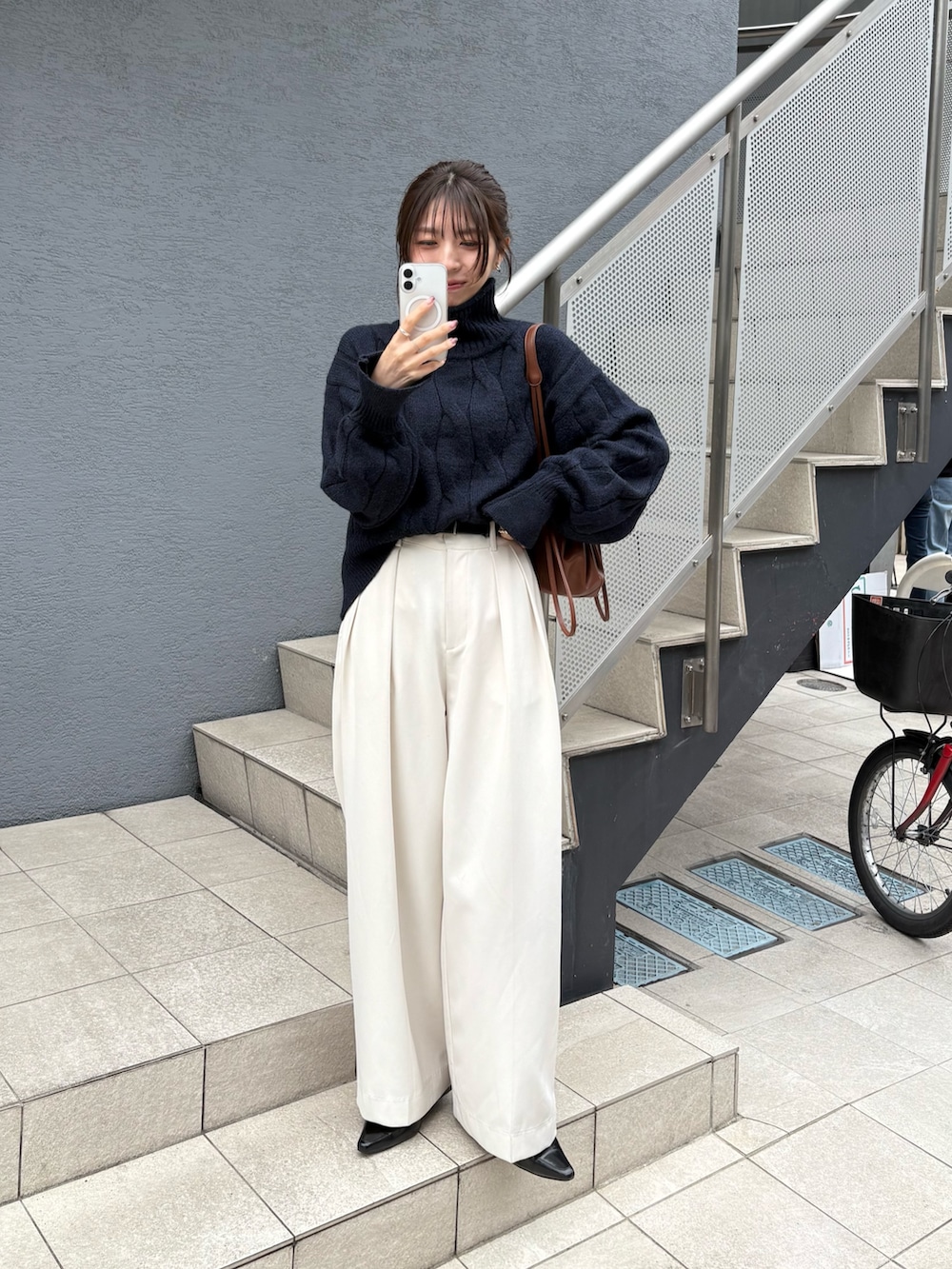 ブルー系のニット/セーター、ブラック系のローファー、ブラウン系のショルダーバッグを着用したレディースの秋コーディネートの2枚目の写真