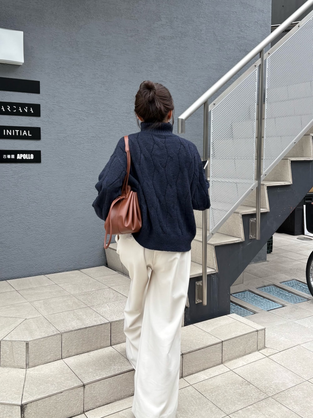 ブルー系のニット/セーター、ブラック系のローファー、ブラウン系のショルダーバッグを着用したレディースの秋コーディネートの3枚目の写真