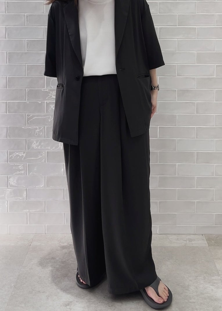 グレー系のサンダル、ホワイト系のTシャツ/カットソー、グレー系のスラックスを着用したレディースの春コーディネートの5枚目の写真