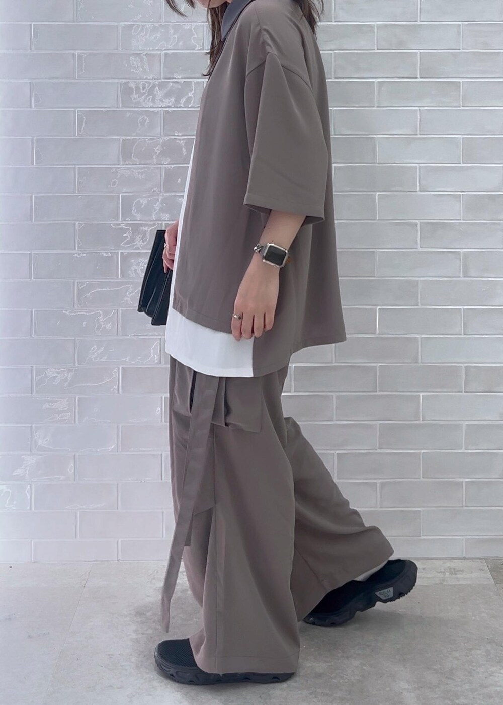 ブラック系のショルダーバッグ、ホワイト系のシャツ/ブラウス、グレー系のカーゴパンツを着用したレディースの夏コーディネートの2枚目の写真