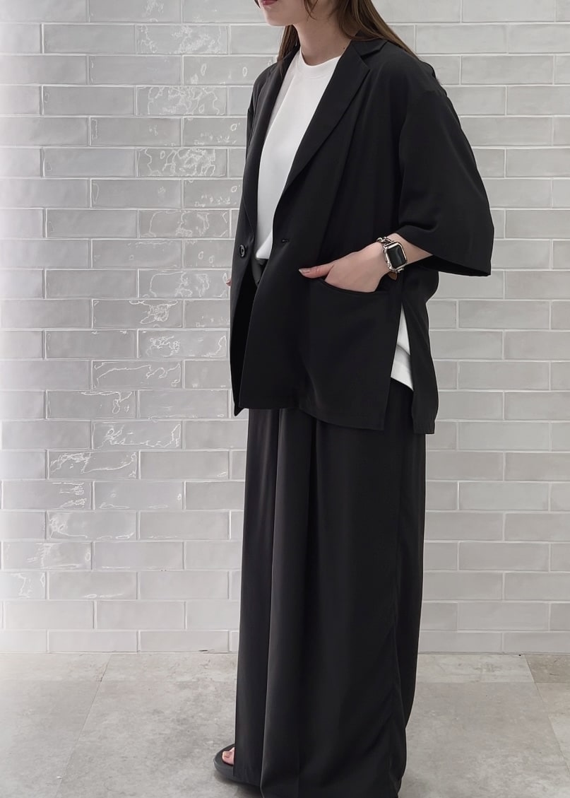 グレー系のサンダル、ホワイト系のTシャツ/カットソー、グレー系のスラックスを着用したレディースの春コーディネートの4枚目の写真