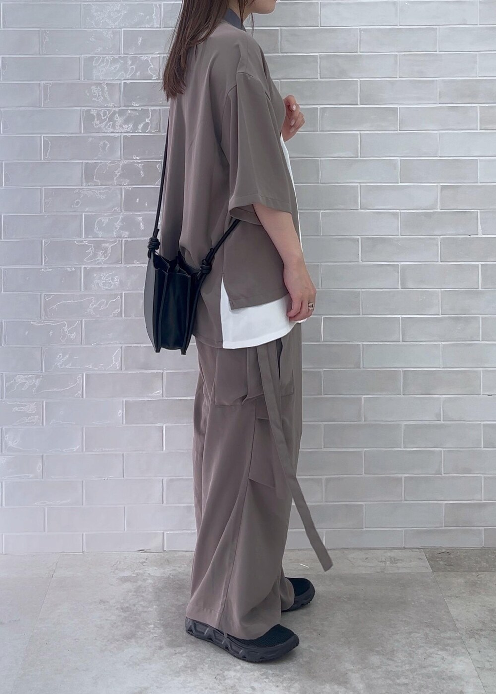 ブラック系のショルダーバッグ、ホワイト系のシャツ/ブラウス、グレー系のカーゴパンツを着用したレディースの夏コーディネートの3枚目の写真