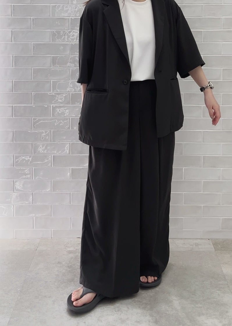 グレー系のサンダル、ホワイト系のTシャツ/カットソー、グレー系のスラックスを着用したレディースの春コーディネートの3枚目の写真