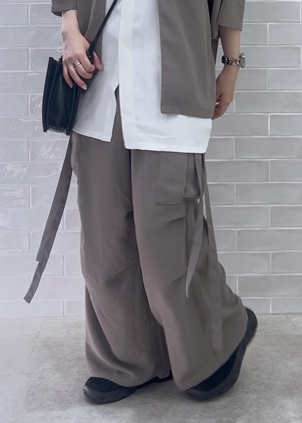 ブラック系のショルダーバッグ、ホワイト系のシャツ/ブラウス、グレー系のカーゴパンツを着用したレディースの夏コーディネートの5枚目の写真