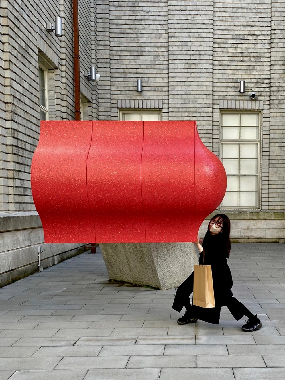 ブラック系のシャツワンピース、ブラック系のベストを着用したレディースの春コーディネートの2枚目の写真