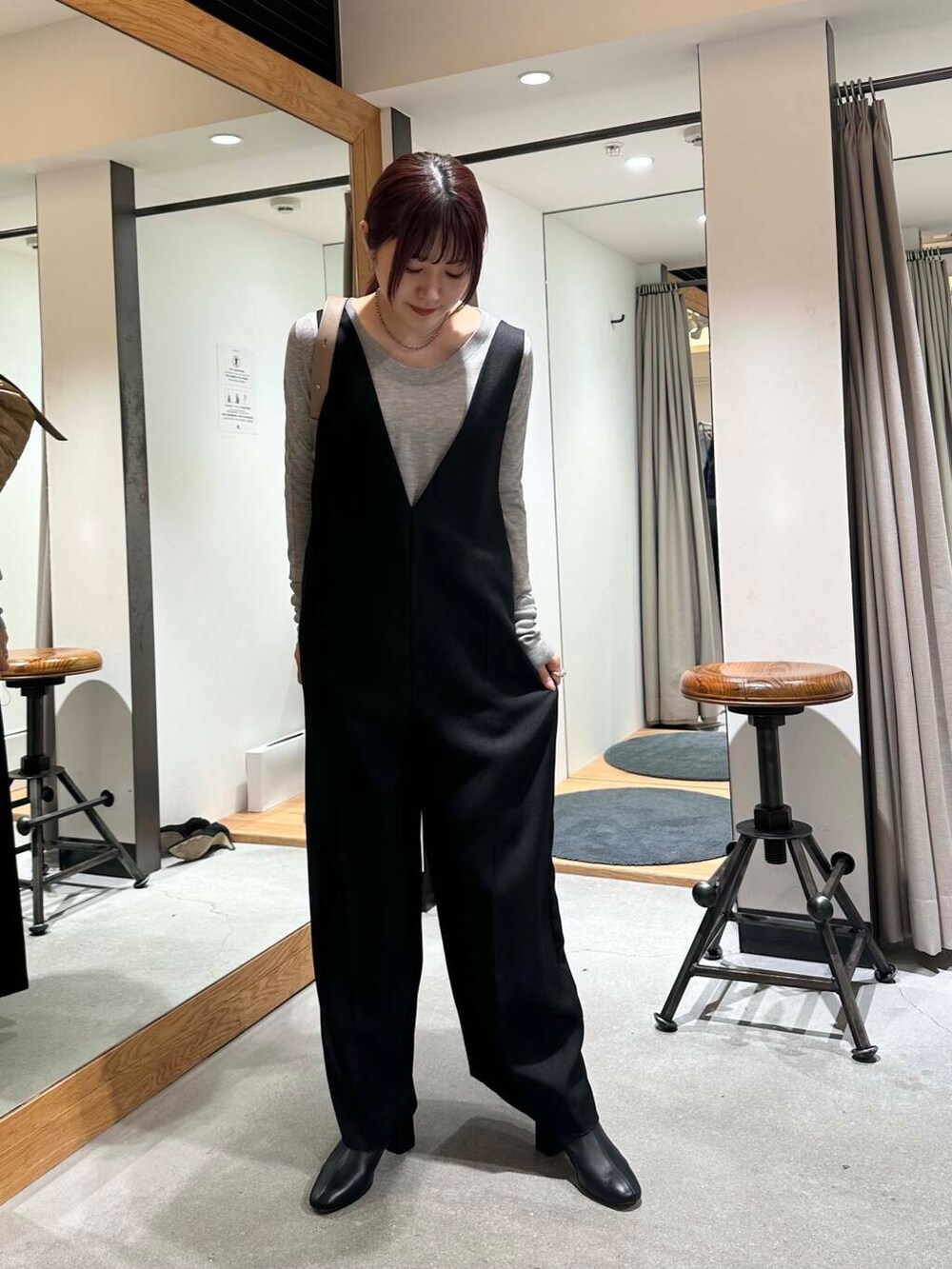 グレー系のニット/セーター、ブラック系のサロペット/オーバーオール、ベージュ系のショルダーバッグを着用したレディースの冬コーディネートの3枚目の写真