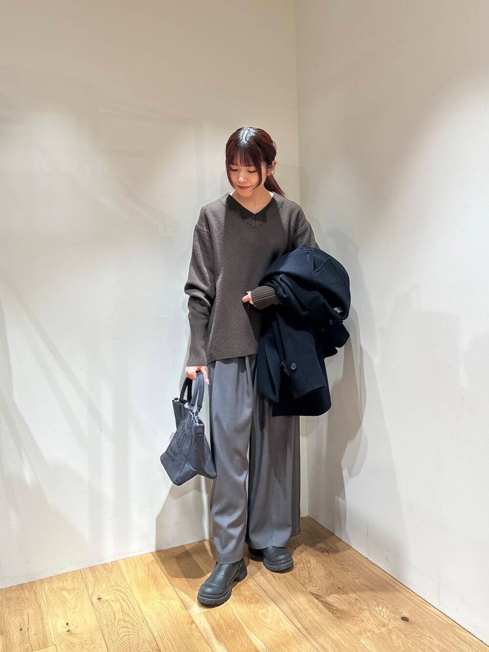ブルー系のピーコート、グレー系のその他パンツ、ブラウン系のニット/セーターを着用したレディースの冬コーディネートの2枚目の写真