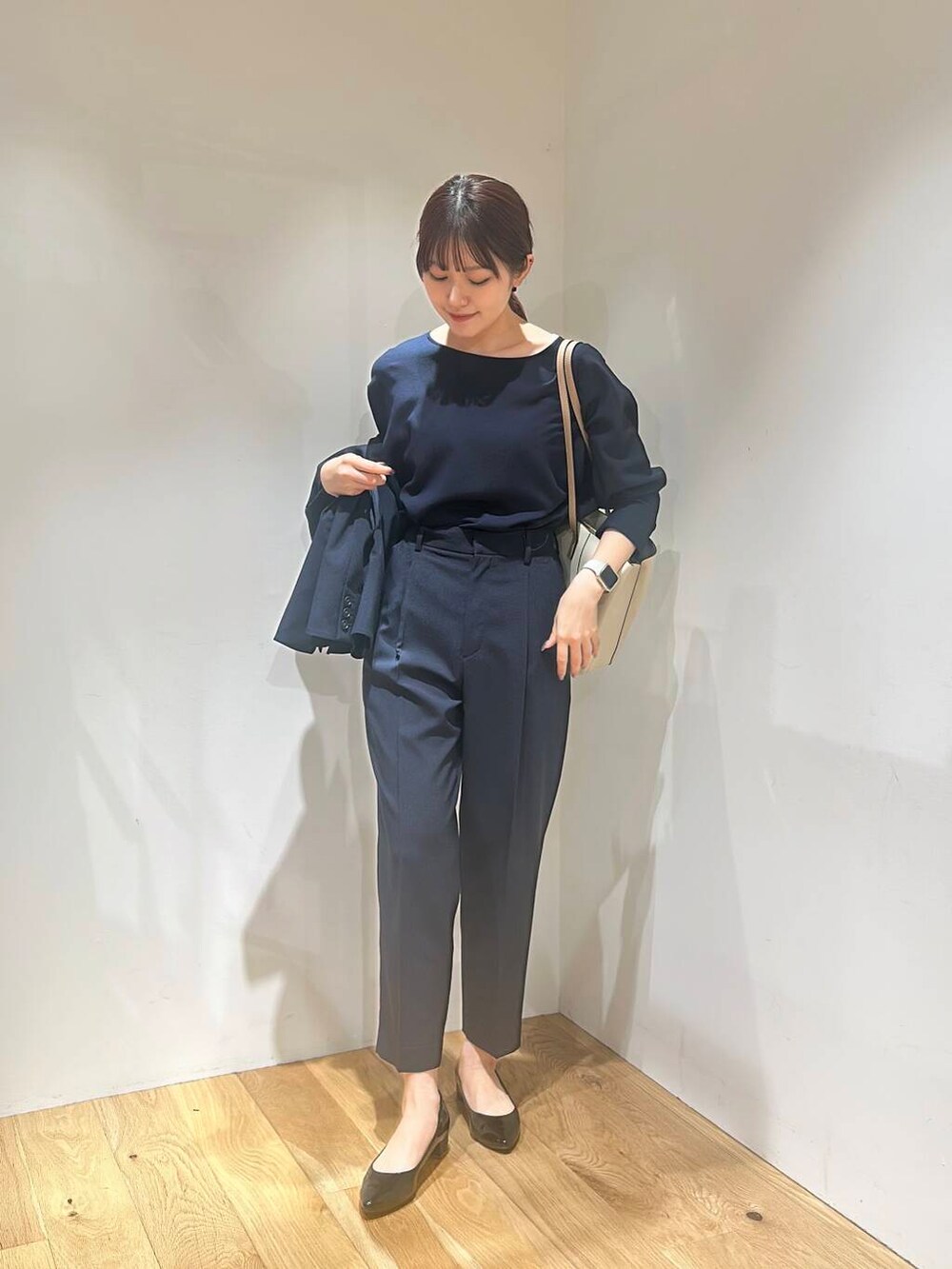 ホワイト系のトートバッグ、ブラック系のパンプス、ブルー系のその他パンツを着用したレディースの春コーディネートの2枚目の写真