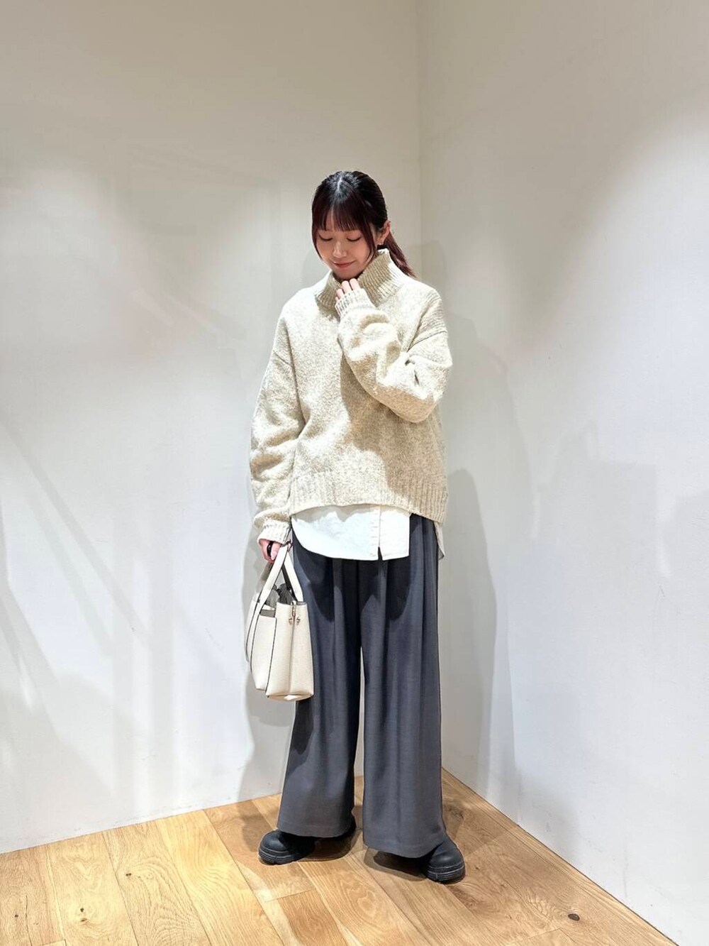 グレー系のその他パンツ、ホワイト系のニット/セーター、ホワイト系のトートバッグを着用したレディースの冬コーディネートの4枚目の写真