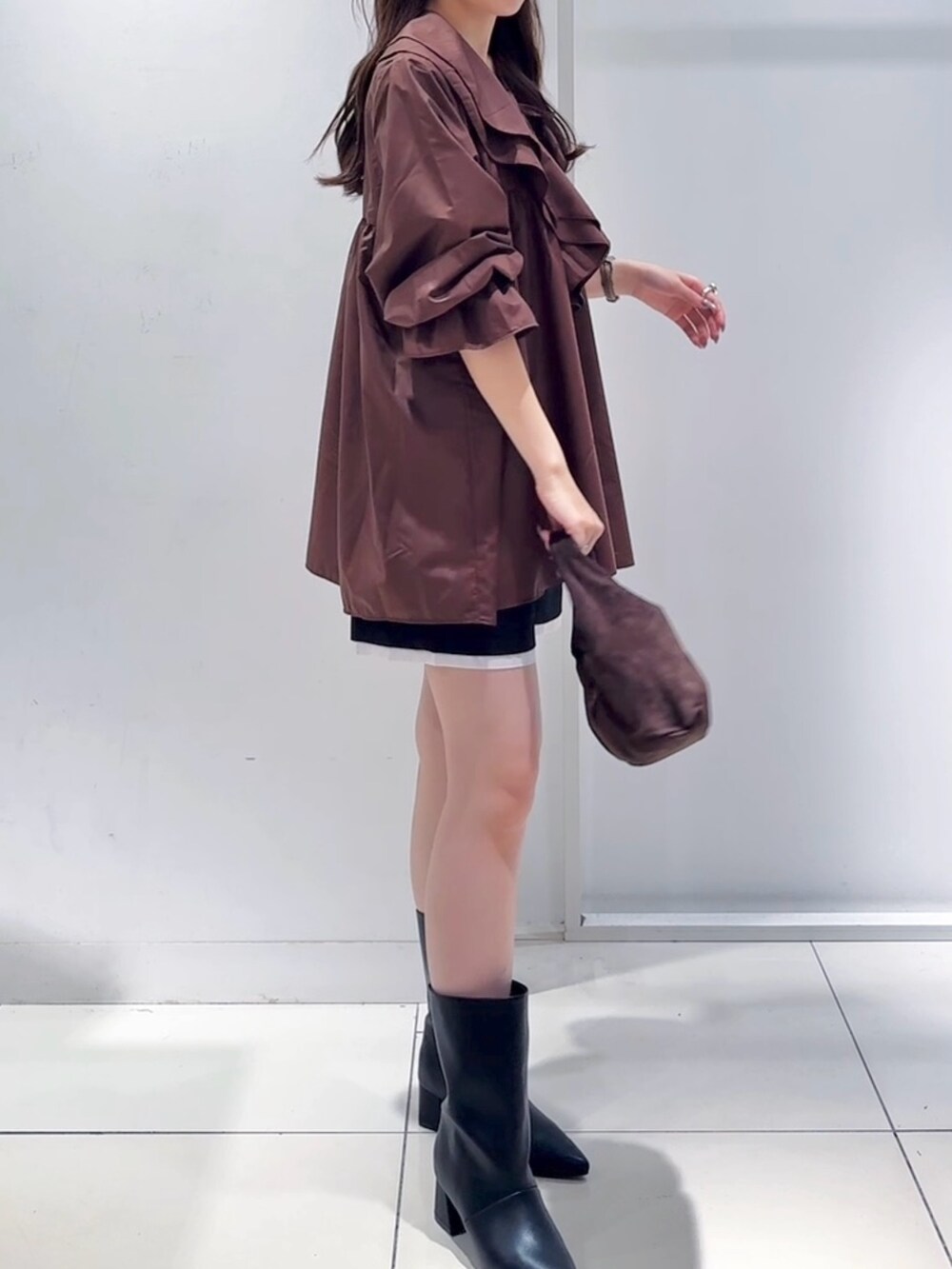 ブラウン系のワンピース、ブラック系のその他パンツ、ブラック系のブーツを着用したレディースの秋コーディネートの2枚目の写真