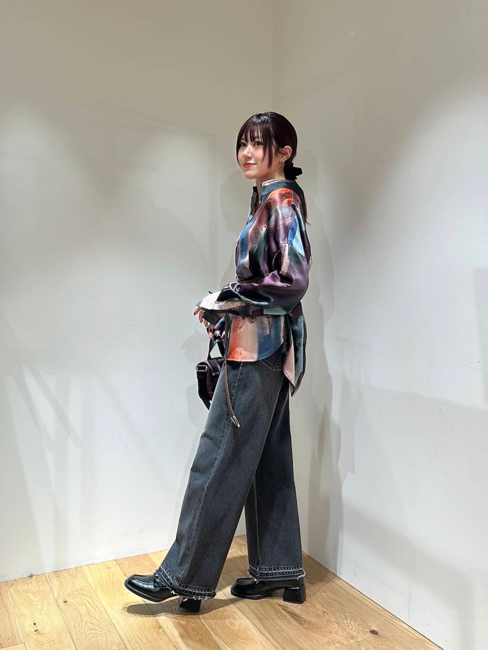 ブラック系のデニムパンツ、ブラウン系のショルダーバッグ、ピンク系のシャツ/ブラウスを着用したレディースの冬コーディネートの4枚目の写真