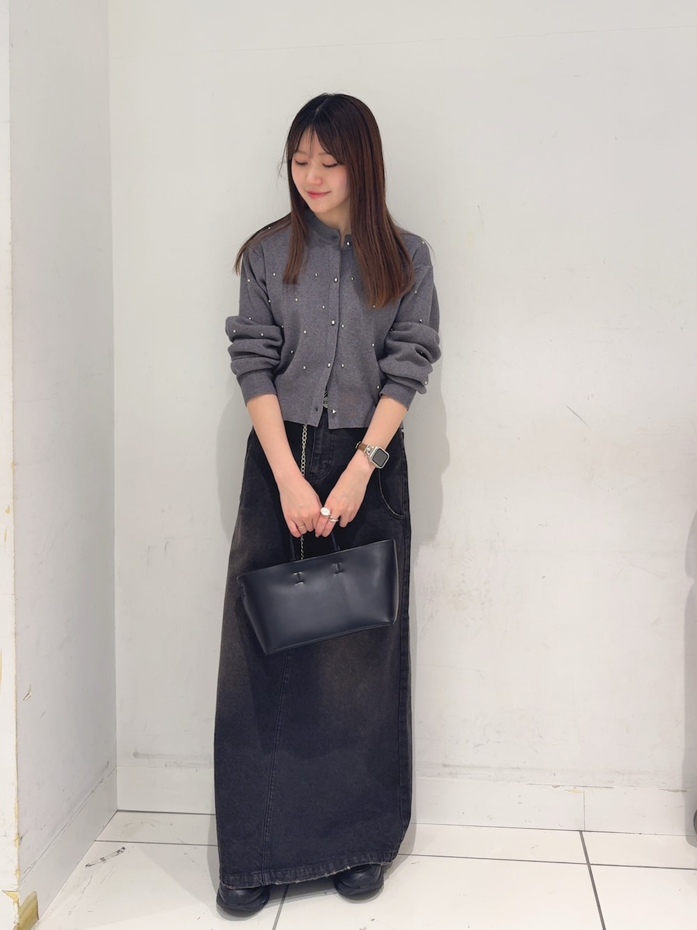 グレー系のカーディガン/ボレロ、ブラック系のスカート、ブラック系のトートバッグを着用したレディースの冬コーディネートの2枚目の写真