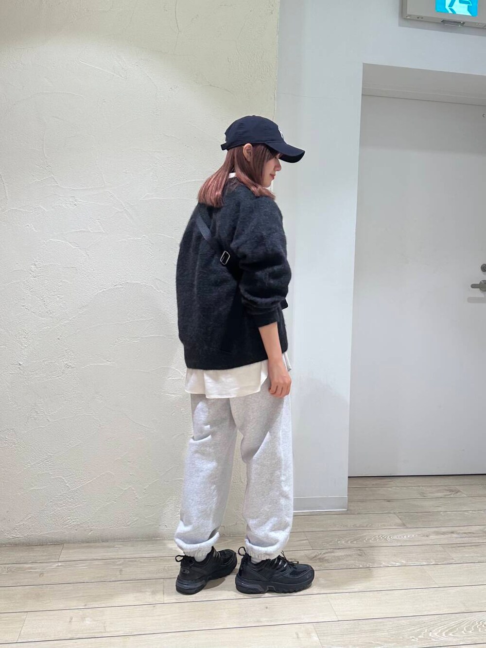 ホワイト系のシャツ/ブラウス、グレー系のニット/セーター、ブラック系のショルダーバッグを着用したレディースの秋コーディネートの3枚目の写真