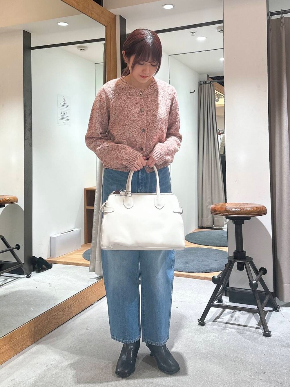 ブルー系のデニムパンツ、ベージュ系のピーコート、ブラック系のブーツを着用したレディースの冬コーディネートの2枚目の写真