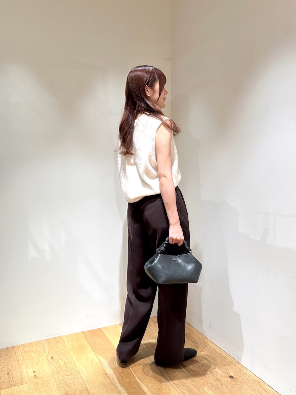 ホワイト系のベスト、ブラウン系のその他パンツ、ブラック系のローファーを着用したレディースの夏コーディネートの2枚目の写真