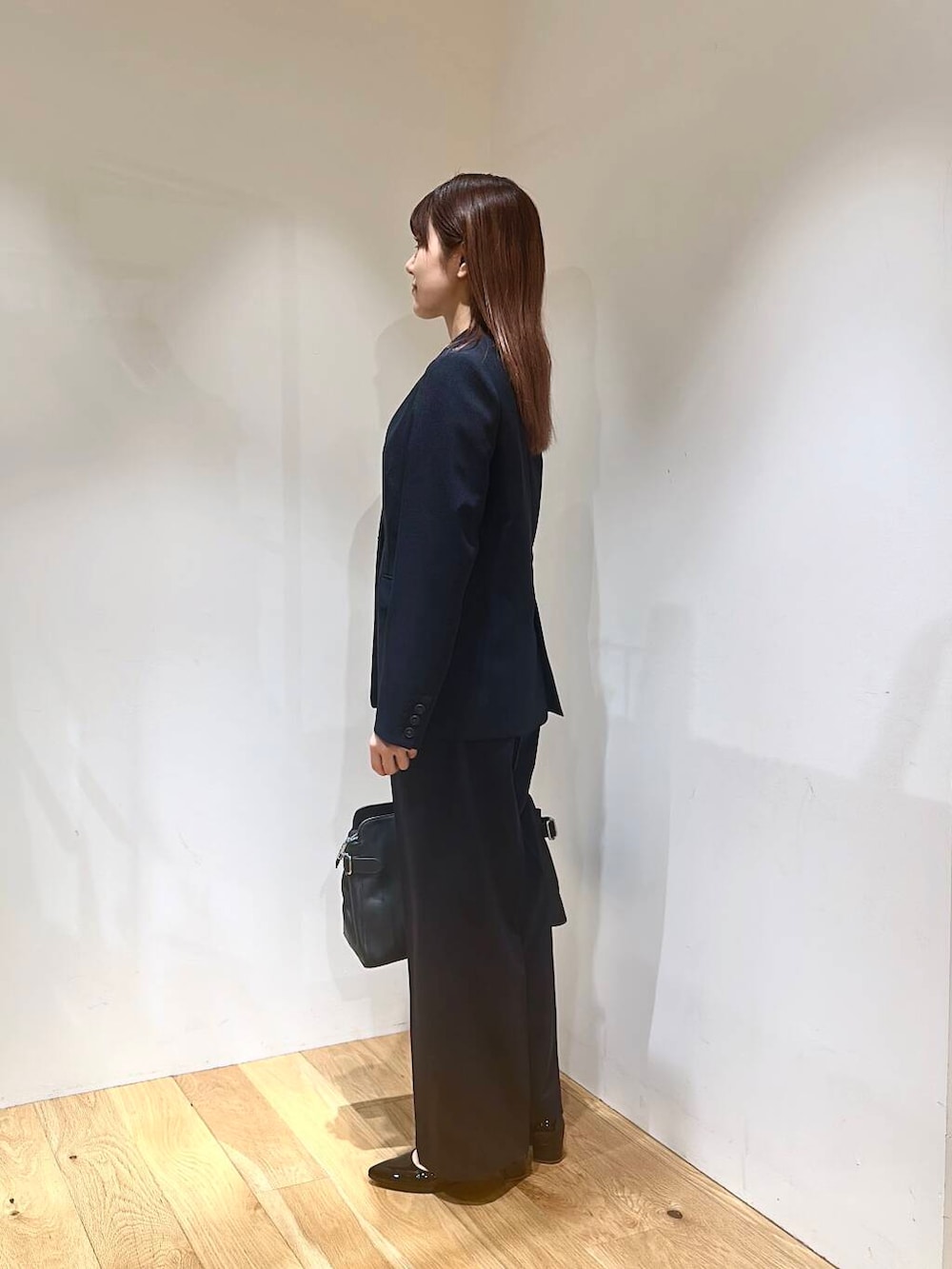 ブラック系のパンプス、ブルー系のその他パンツ、ブルー系のノーカラージャケットを着用したレディースの春コーディネートの3枚目の写真