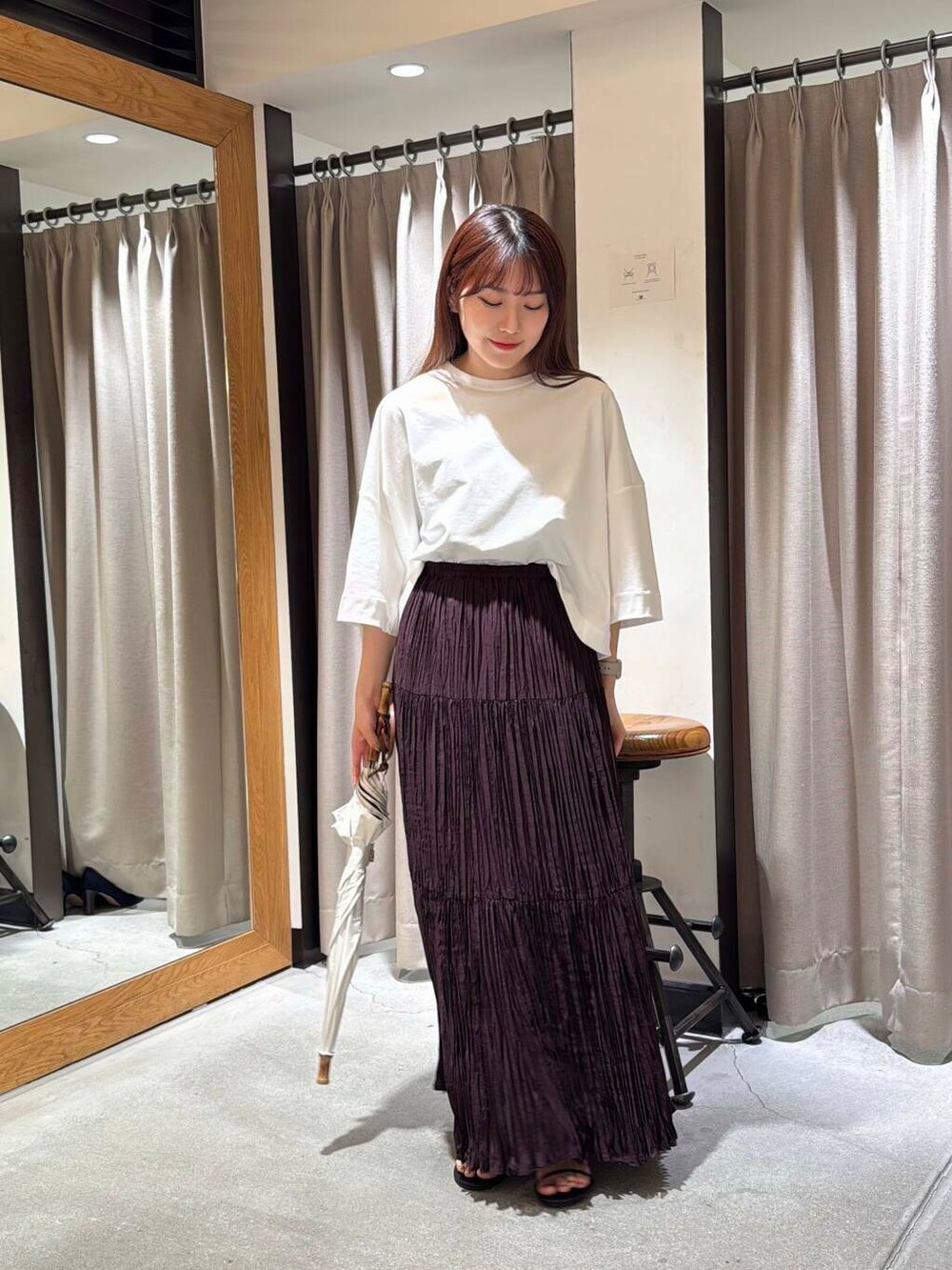 ホワイト系のTシャツ/カットソー、ブラウン系のスカート、ブラック系のサンダルを着用したレディースの春コーディネートの5枚目の写真