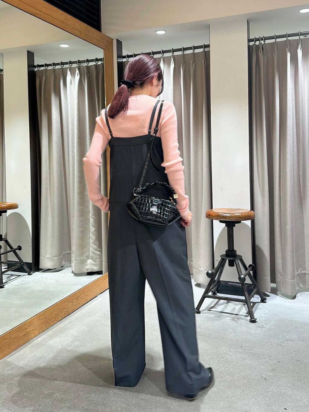 ブラック系のパンプス、ブラック系のショルダーバッグ、グレー系のサロペット/オーバーオールを着用したレディースの冬コーディネートの4枚目の写真