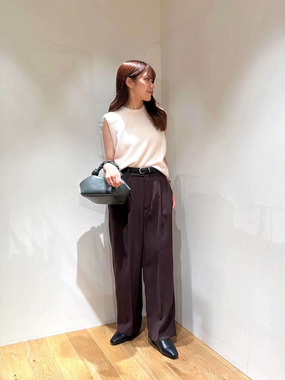 ホワイト系のベスト、ブラウン系のその他パンツ、ブラック系のローファーを着用したレディースの夏コーディネートの3枚目の写真