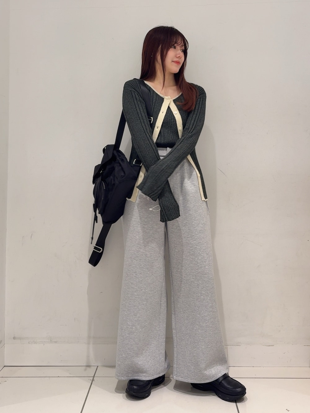 グレー系のニット/セーター、グレー系のその他パンツ、ブラック系のバックパック/リュックを着用したレディースの春コーディネートの5枚目の写真