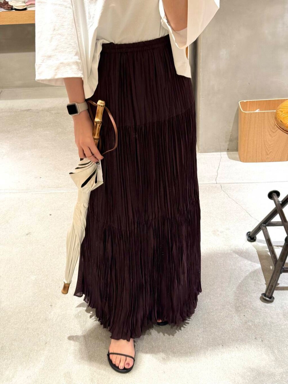 ホワイト系のTシャツ/カットソー、ブラウン系のスカート、ブラック系のサンダルを着用したレディースの春コーディネートの3枚目の写真