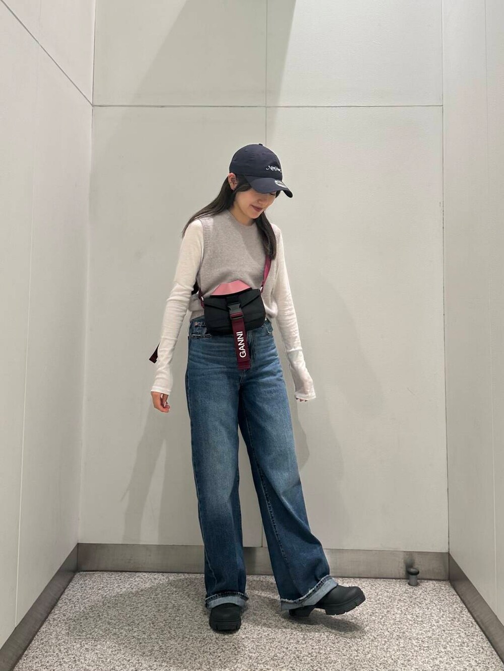 ブラック系のブーツ、ホワイト系のTシャツ/カットソー、ブルー系のデニムパンツを着用したレディースの秋コーディネートの2枚目の写真