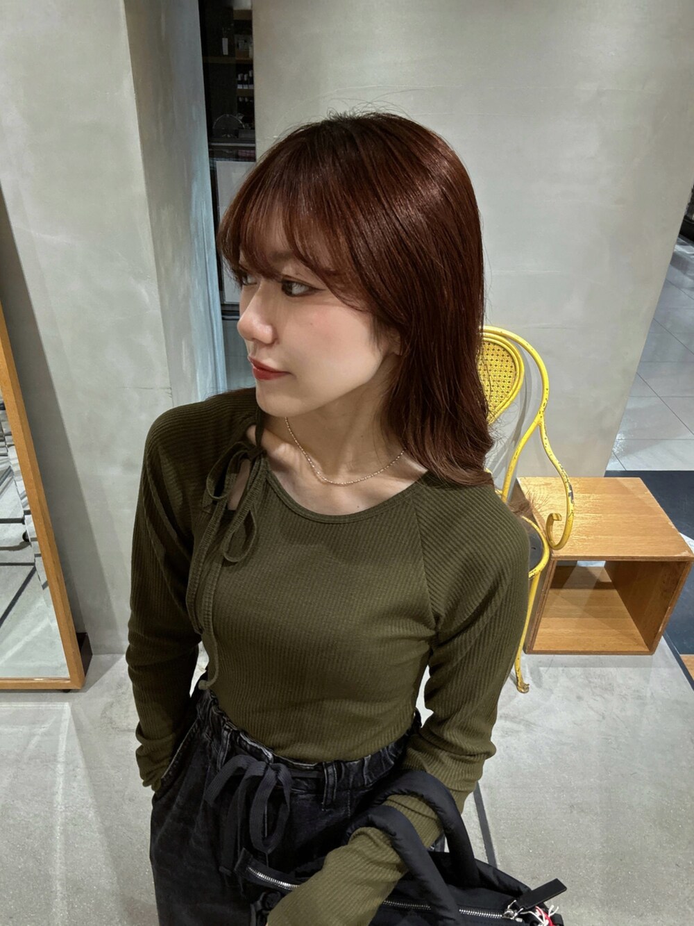 グリーン系のTシャツ/カットソー、ブラック系のデニムパンツ、ブラック系のトートバッグを着用したレディースの秋コーディネートの3枚目の写真