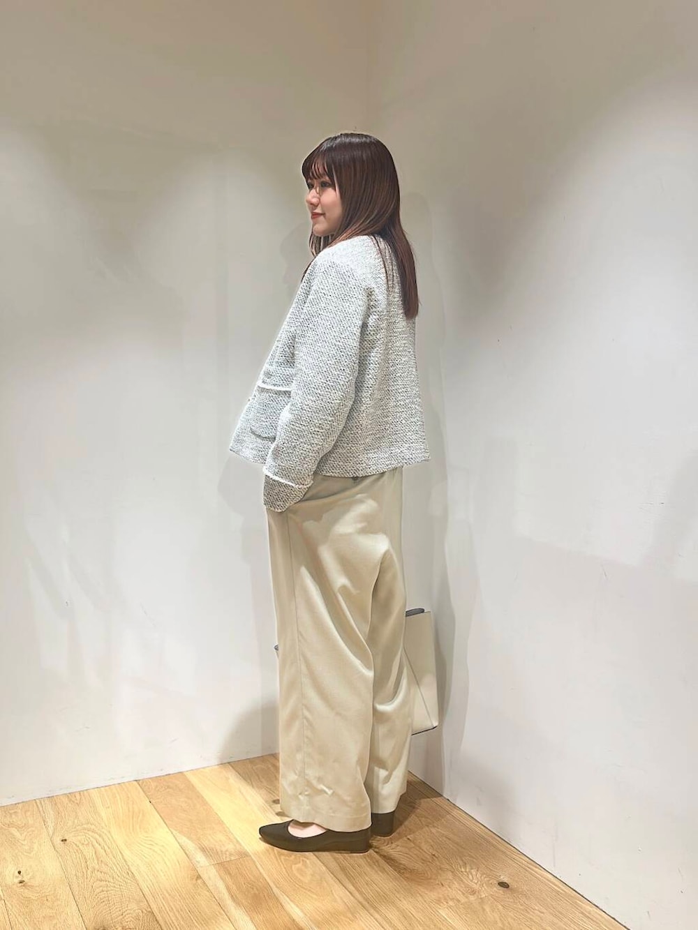 ホワイト系のトートバッグ、ブラック系のパンプス、ベージュ系のサロペット/オーバーオールを着用したレディースの春コーディネートの4枚目の写真