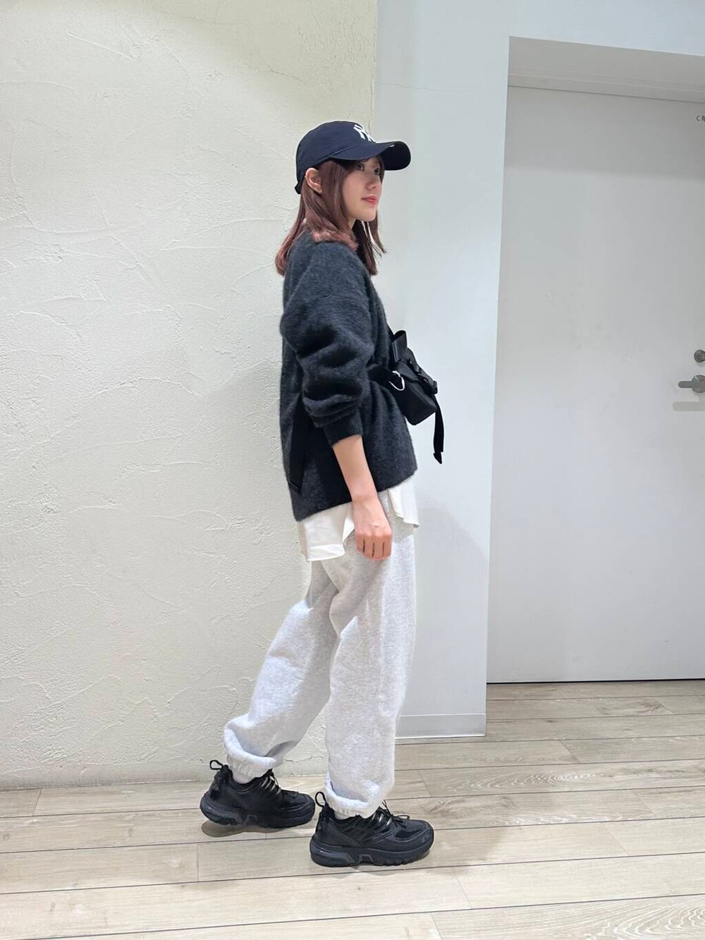 ホワイト系のシャツ/ブラウス、グレー系のニット/セーター、ブラック系のショルダーバッグを着用したレディースの秋コーディネートの2枚目の写真