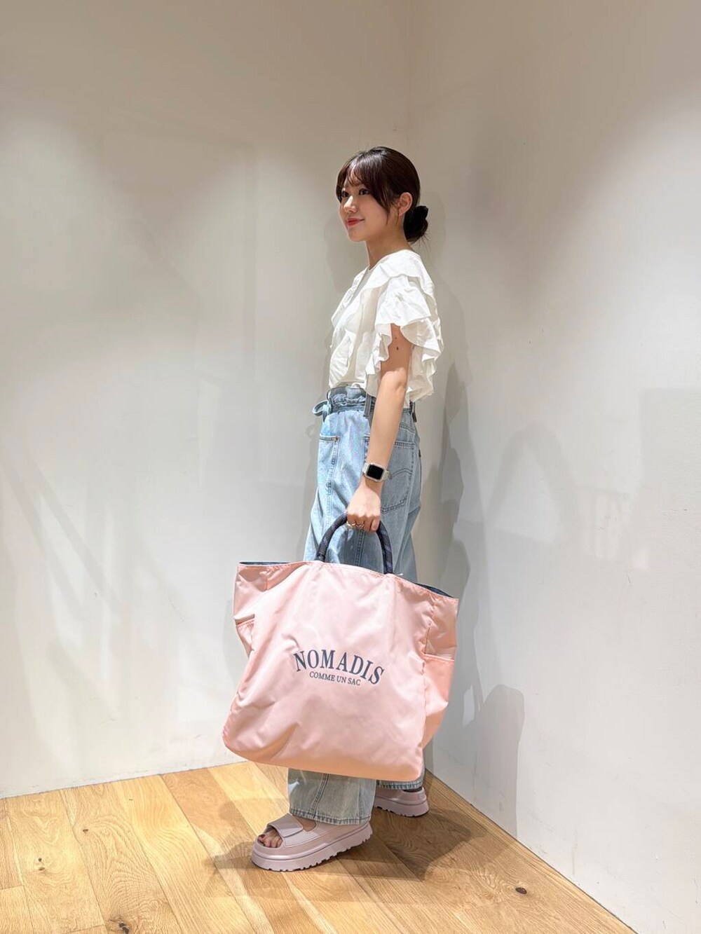 ブルー系のデニムパンツ、ピンク系のトートバッグ、ピンク系のサンダルを着用したレディースの春コーディネートの3枚目の写真