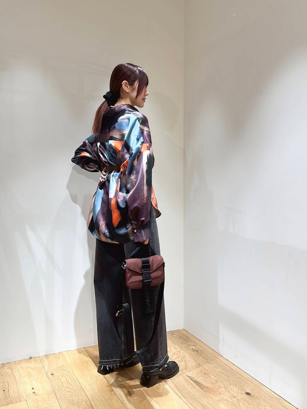 ブラック系のデニムパンツ、ブラウン系のショルダーバッグ、ピンク系のシャツ/ブラウスを着用したレディースの冬コーディネートの3枚目の写真