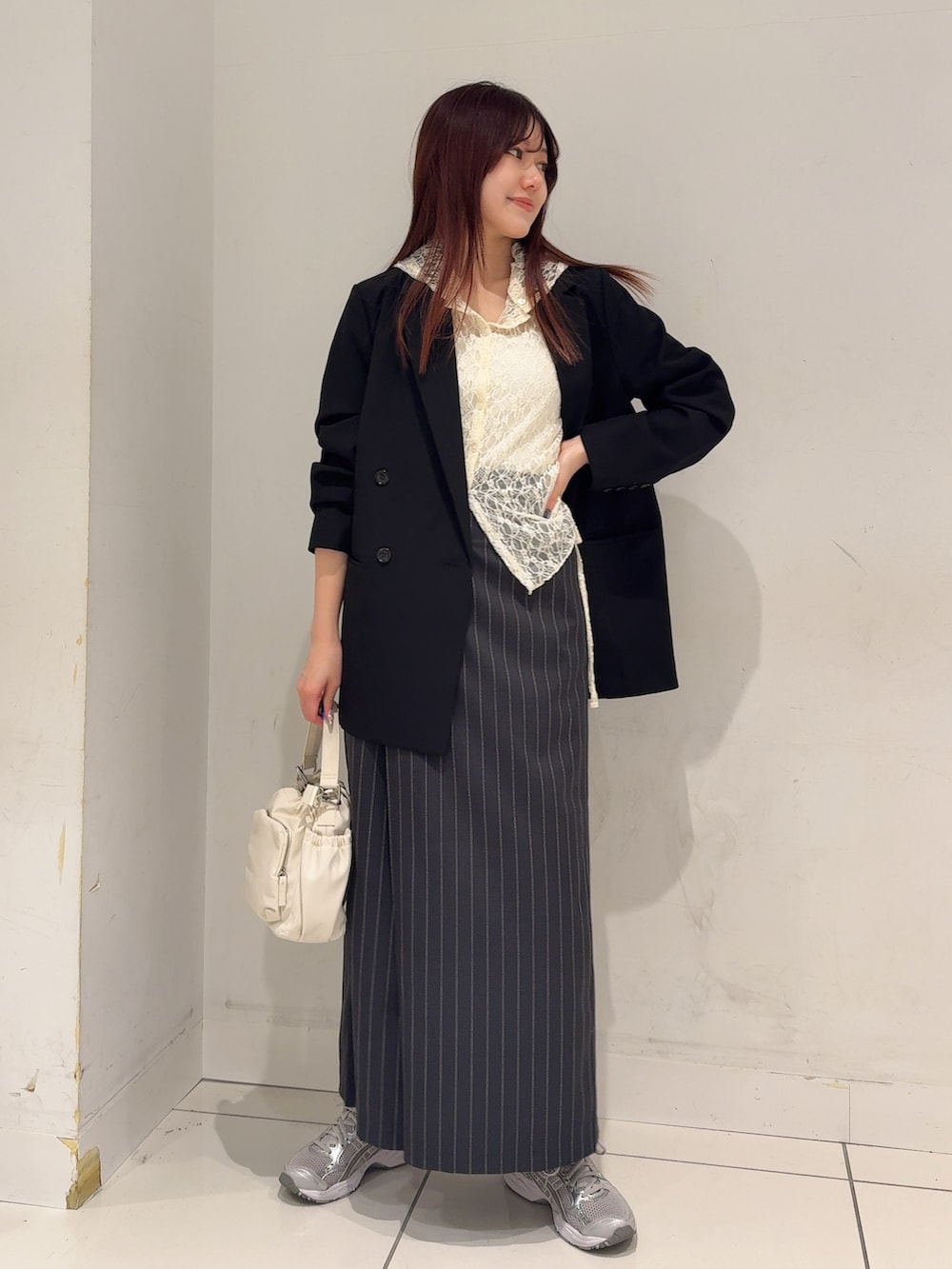 ホワイト系のその他トップス、ブラック系のテーラードジャケット、グレー系のスカートを着用したレディースの春コーディネートの2枚目の写真
