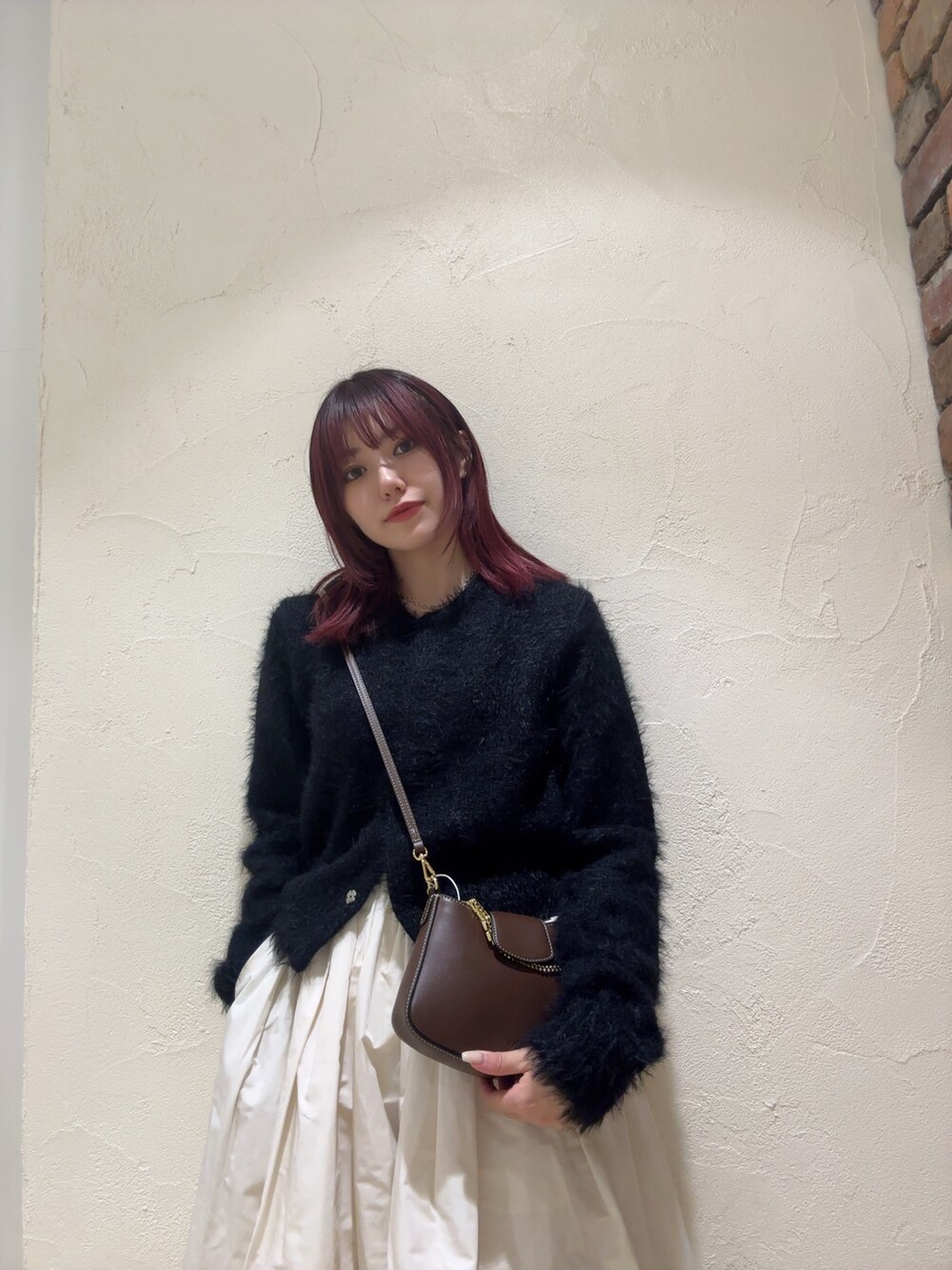 ホワイト系のスカート、ブラック系のカーディガン/ボレロを着用したレディースの秋コーディネートの2枚目の写真