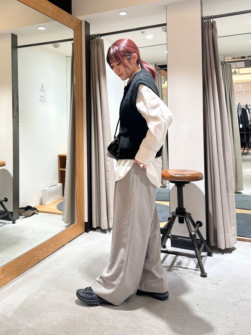 グレー系のその他パンツ、ホワイト系のTシャツ/カットソー、ブラック系のベストを着用したレディースの冬コーディネートの2枚目の写真