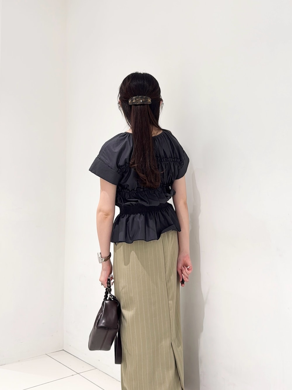 グレー系のシャツ/ブラウス、ベージュ系のスカート、ブラウン系のショルダーバッグを着用したレディースの夏コーディネートの3枚目の写真
