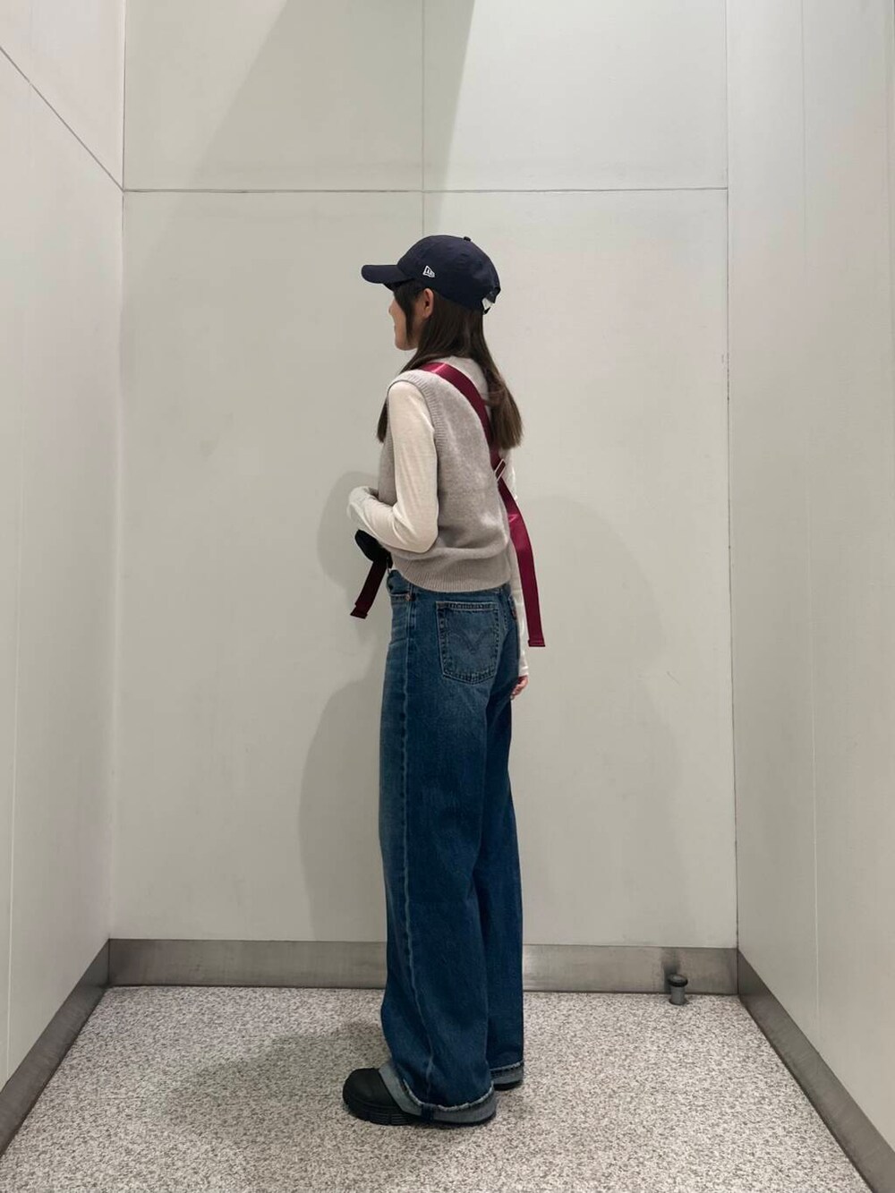 ブラック系のブーツ、ホワイト系のTシャツ/カットソー、ブルー系のデニムパンツを着用したレディースの秋コーディネートの3枚目の写真